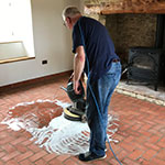 man cleaning his new handmade Kent original floor tiles.